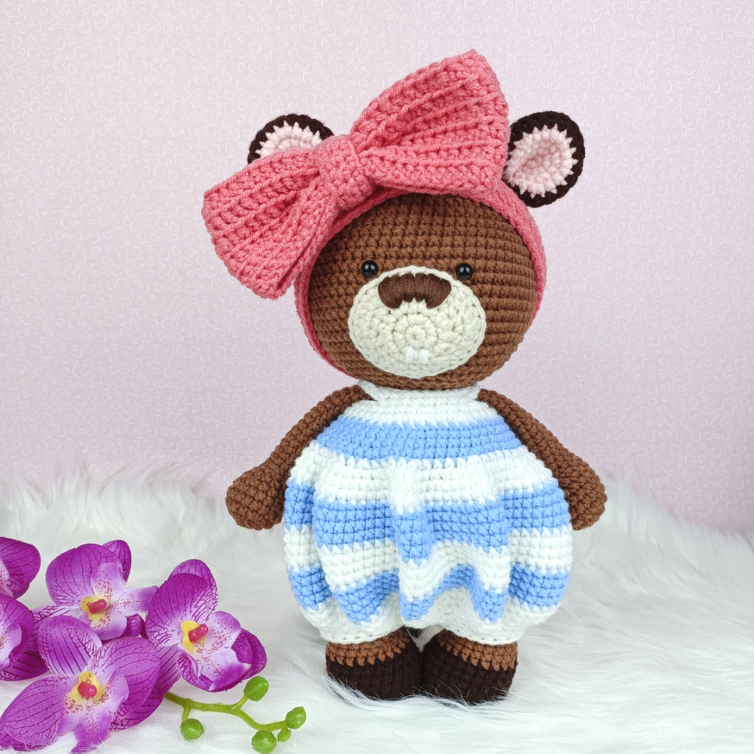 Cute crocheted beaver in baggy romper and big ribbon head band.