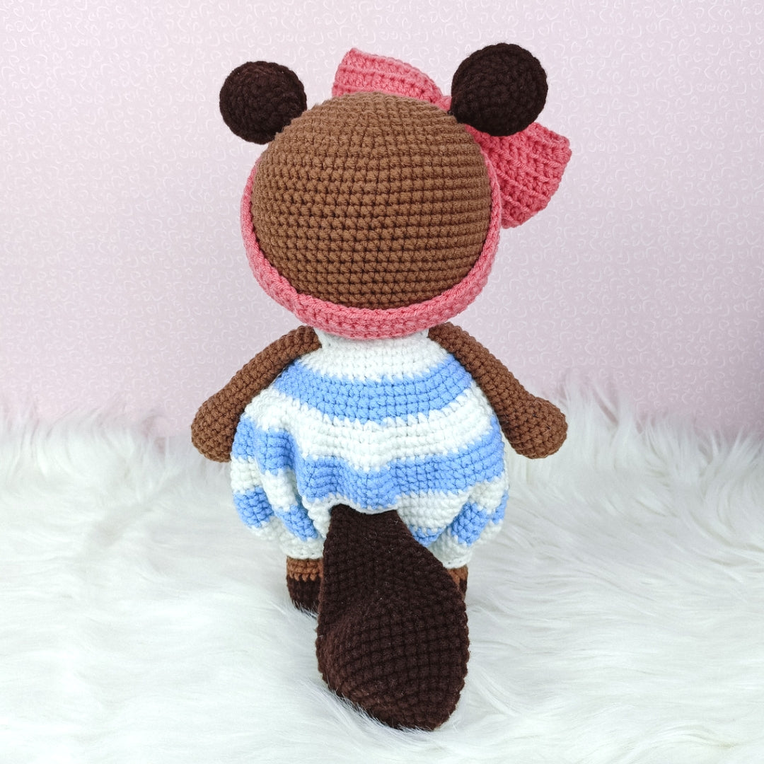 Cute crocheted beaver in baggy romper and big ribbon head band.