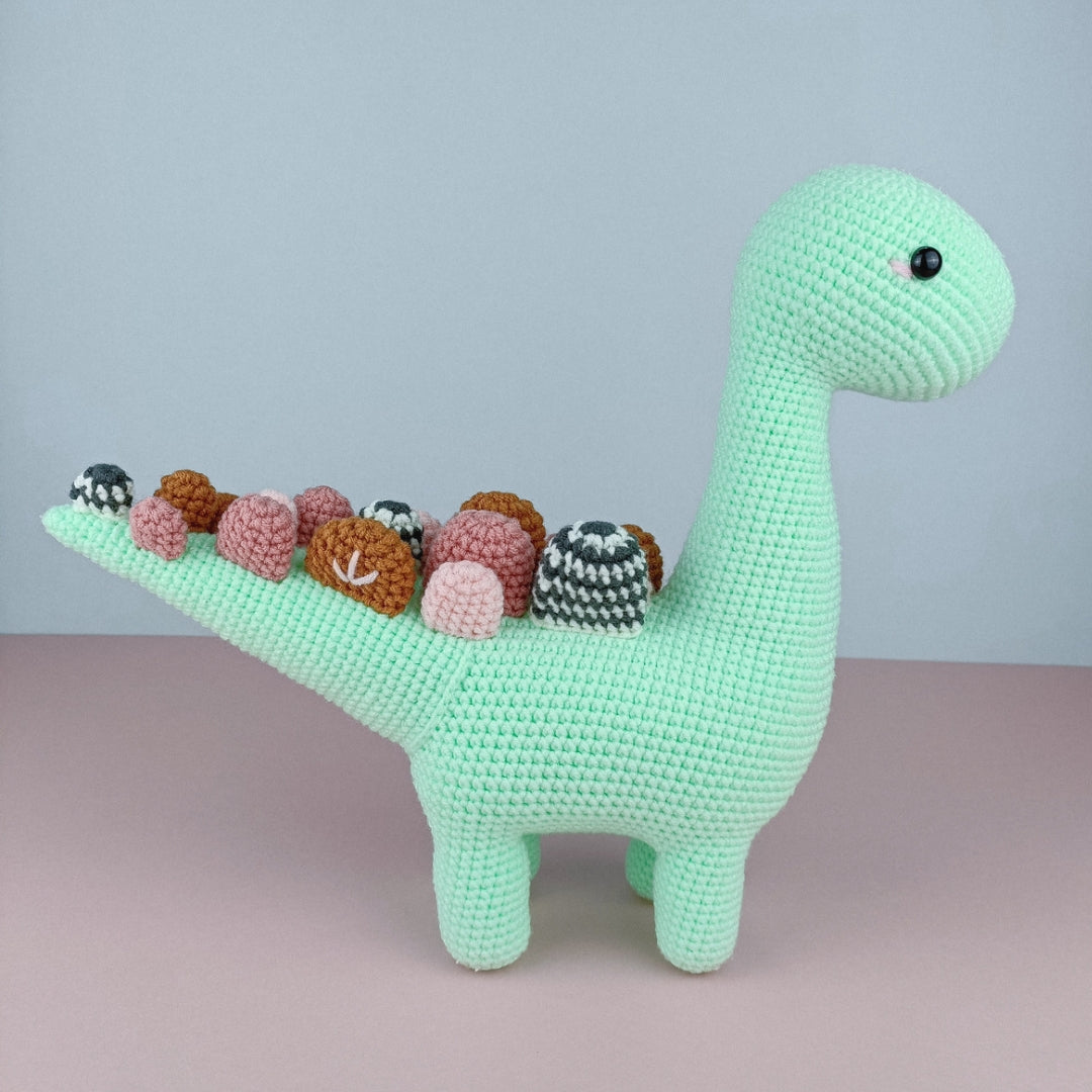 Adorable stuffed dinosaur with colourful tail