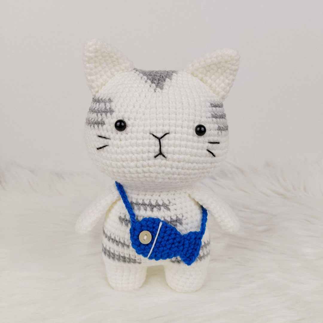 Adorable crocheted cat who loves his fish pouch.