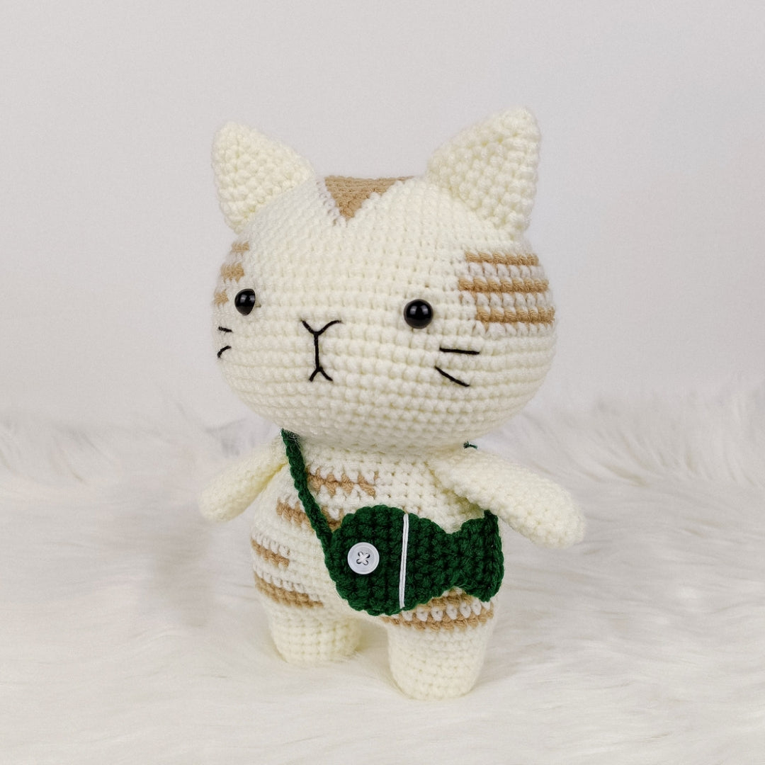 Adorable crocheted cat who loves his fish pouch.
