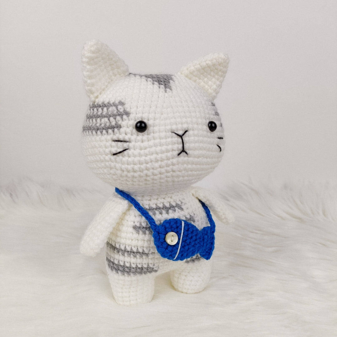 Adorable crocheted cat who loves his fish pouch.